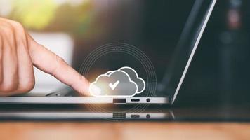Human hand touches the laptop, the concept of transferring, uploading, and downloading data, cloud computing technology transformation, online storage, large data backup and transmission. photo