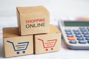 Online shopping, Shopping cart box on calculator, import export, finance commerce. photo