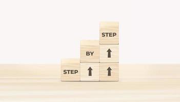 The word step by step on wooden cubes. Achievement or progress in business career. 3D illustration. photo