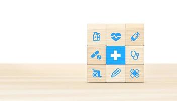 Health insurance concept, wooden blocks with healthcare medical icons on blue background, copy space. 3D illustration. photo