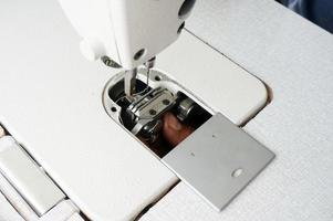 un anciano arreglando una máquina de coser, con enfoque selectivo foto
