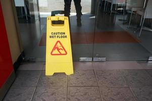 Precaución señal de piso mojado en el piso del restaurante. foto