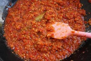 sambal tumis or sambal goreng is indonesian stir fried chili sauce. Ingredient is chili, salt, garlic, shalot and lime leaves. photo