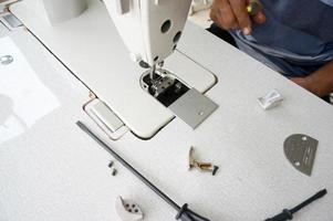 an old man fixing a sewing machine, With Selective Focus photo