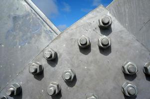 Bolts on a fragment of a massive girder bridge gray. photo