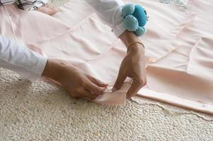 Closeup of a woman's hands pinning large upholstery pins into plain fabric, With Selective Focus photo