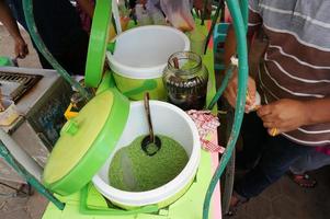 Hand are mixing Cendol with coconut milk , Indonesia desserts called Cendol photo