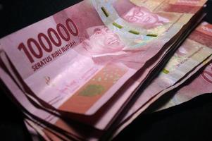 Money indonesian Rupiah Banknotes, one hundred thousand rupiah, Isolated on black background, Indonesian Currency . photo