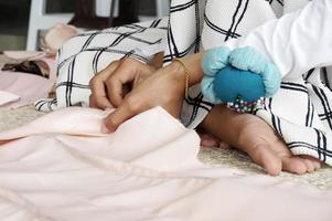 Closeup of a woman's hands pinning large upholstery pins into plain fabric, With Selective Focus photo