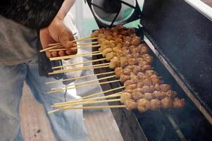 albóndigas a la parrilla en brochetas, bakso pentol bakar con salsa de soja foto