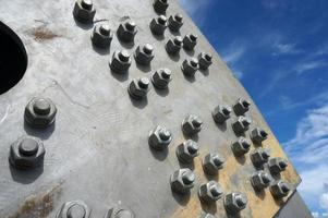 Bolts on a fragment of a massive girder bridge gray. photo