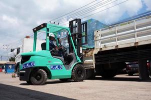 Sangatta, East Kalimantan, Indonesia, 2020 - forklift driver loading cargo pallet shipment with a truck crane at perking area warehouse. photo