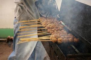 Grilled meatballs in skewers, bakso pentol bakar with soy sauce photo