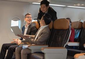 Happiness business people working together on laptop during flight photo