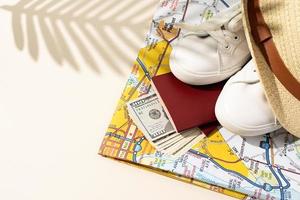 traveler accessories with passport, money and clothes on peach colored background, copy space and shadow overlay photo