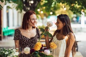 dos mujeres jóvenes componen un hermoso ramo festivo. foto