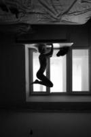 woman doing yoga asana on window sill photo