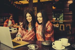 dos chicas viendo algo en la computadora portátil foto