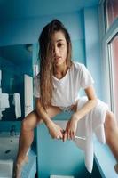 Beautiful, young woman in the bathroom is having fun photo