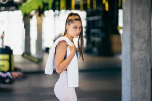 Healthy young female relaxed after training in gym. photo