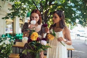 dos mujeres jóvenes componen un hermoso ramo festivo. foto