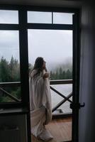 Woman drinking tea on cozy balcony of a country house. photo