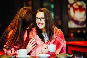 Two young and beautiful girls gossiping photo