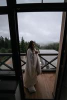 Woman drinking tea on cozy balcony of a country house. photo