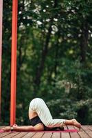 A young woman in doing yoga in the yard photo