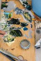 Close up of woman's hand mix paints in palette photo