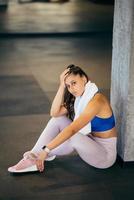 Healthy young female sitting relaxed after training in gym. photo