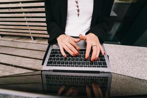 Cerrar imagen de manos de mujer escribiendo en la computadora portátil. foto