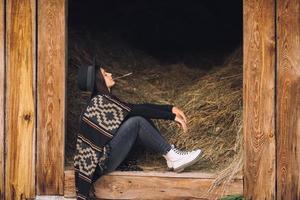 Young brunette woman sitting at the barn. Country style. photo