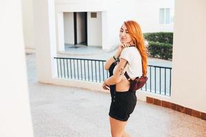 mujer con el pelo largo y rojo de pie junto a foto