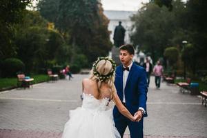 el novio sostiene a la novia en sus brazos y la retuerce foto