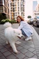 Woman play with a dog at street photo