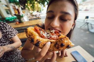 Charming young beautiful woman is eating pizza. photo
