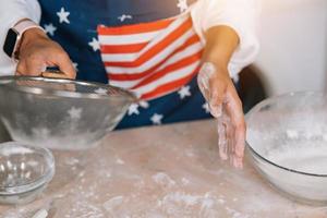 Woman's hands sifting flour through sieve. Selective focus. photo