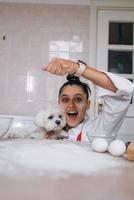 Woman is playing with a dog while pouring flour photo