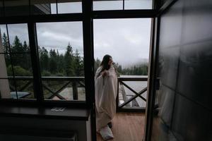 Woman drinking tea on cozy balcony of a country house. photo