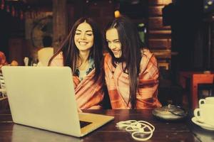 dos chicas viendo algo en la computadora portátil foto