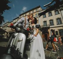 bride and groom on vintage motor scooter photo