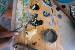 Close up of woman's hand mix paints in palette photo