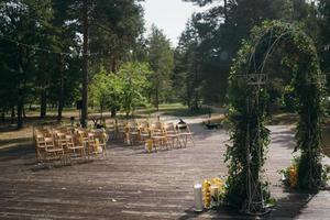 Wedding arch is decorated with green leaves and lemons. photo