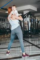 joven madre con su hijo pequeño en el gimnasio foto