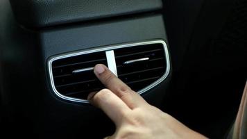 Close up hand adjusting the air conditioning vents in an automobile video