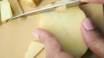 Person cuts raw potato into thin pieces video