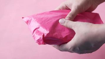 paquete rosa sostenido en las manos de cerca video