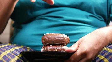 Mens picks omhoog chocola donut naar eten van bord video