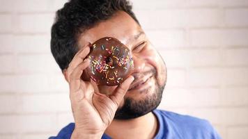 Mens houdt donut omhoog looks door gat video